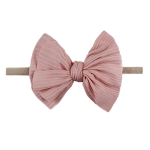 Détail du bandeau bébé rose en coton côtelé avec grand nœud et sangle élastique
