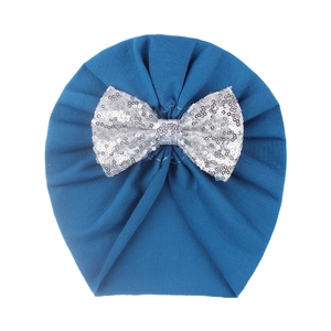 Detail of teal baby turban hat with a large sparkling silver sequined bow on front
