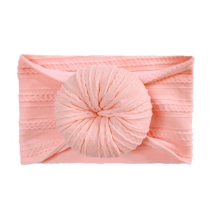 Detail of soft pink knitted baby headband with decorative donut knot and cable pattern