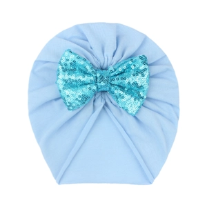 Infant light blue cotton turban hat featuring a shiny green sequin bow decoration