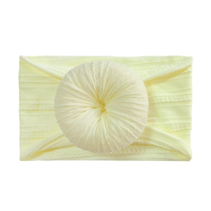 Soft light yellow nylon headband for babies featuring a decorative donut knot detail