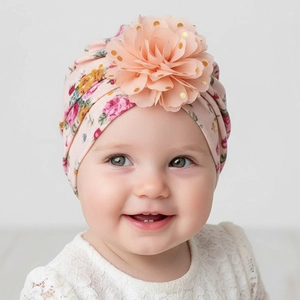 Detailed view of baby floral turban hat with a large gold foil polka dot chiffon flower