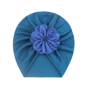 Dettaglio del turbante per neonati blu scuro con un grande fiore in tessuto 3D e perline