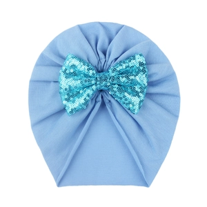 Detailed view of baby light blue turban hat with a large sequined bow decoration