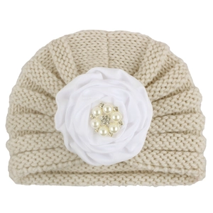Bonnet en tricot beige pour bébé avec grande fleur en satin blanc et centre en perles
