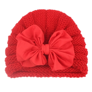 Infant red knitted hat with a large decorative bow, soft baby headwrap for winter