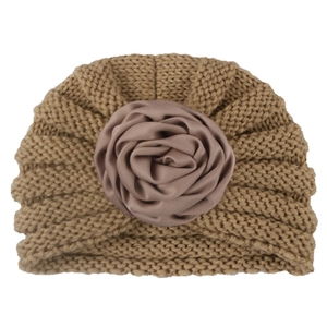 Knitted baby turban hat in camel brown featuring a large decorative satin flower