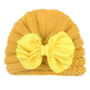 Infant mustard yellow knitted turban hat with large bright yellow bow decoration