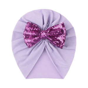 Detail of baby turban hat in lavender cotton with a sparkling purple sequin bow accent