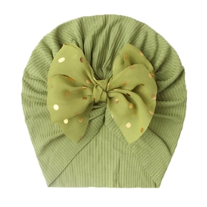 Detail of green ribbed baby turban hat with a large golden polka dot bow decoration