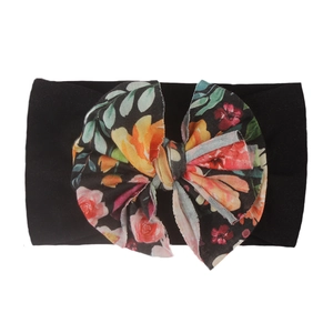 Détail d'un bandeau pour bébé avec nœud à fleurs et bande élastique en nylon noir