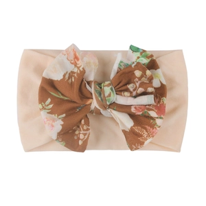 Vue détaillée du bandeau bébé avec grand nœud à imprimé floral vintage et rose rétro