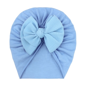 Detailed view of light blue baby turban hat with textured waffle bow on soft cotton fabric