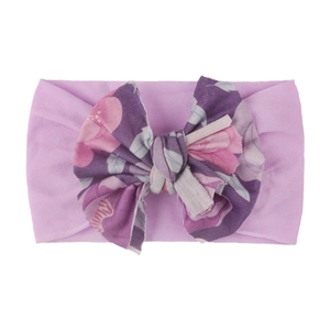 Détail du bandeau bébé avec nœud floral rose en tissu de nylon doux et extensible