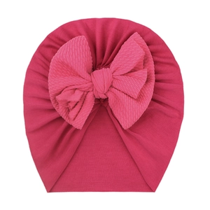 Detailed view of the rose pink waffle texture bow on a soft newborn turban hat