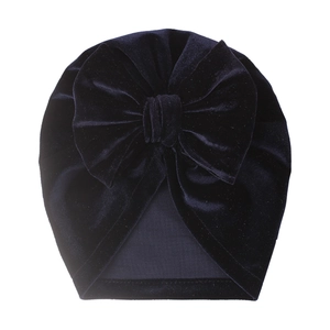 Close-up of navy blue velvet baby turban hat featuring a large soft decorative bow