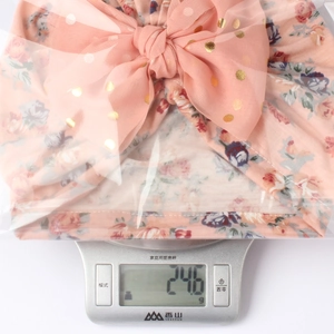 Detail view of pink floral baby turban hat with gold dot mesh bow weighing 24.6g