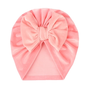 Close-up of soft pink velvet baby turban hat with a large decorative bow detail
