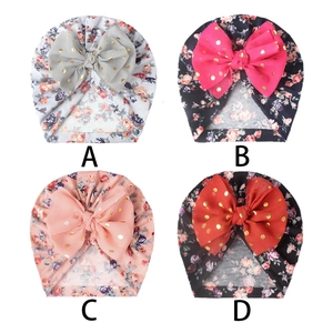 Detail view of baby turban hats with floral prints and large mesh bows in four styles
