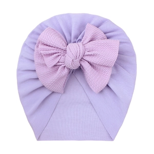 Detail of light purple baby turban hat featuring textured bubble fabric bow and soft knit fabric