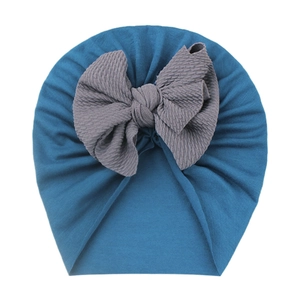 Detailed texture of peacock blue baby turban hat with a large grey waffle bow decoration