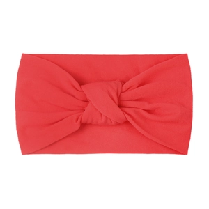 Detail showing red knitted texture and classic twisted knot design on the baby headband