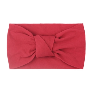Detail of red soft nylon baby headband showing double-layered fabric and twisted knot texture