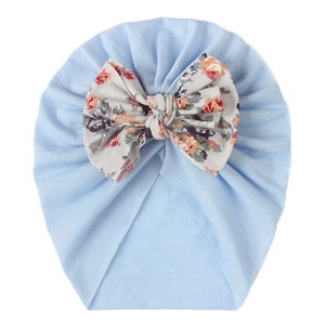 Close-up of light blue baby turban featuring a large floral rose print bow detail