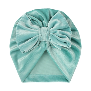Mint green velvet baby turban hat with a large decorative bow and knotted design