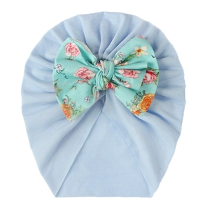 Detail of baby turban hat with a mint green floral print bow and blue ribbed knit fabric
