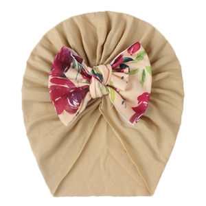 Detail of baby turban hat in khaki fabric with large floral print bow decoration