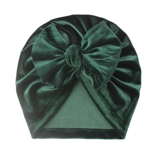 Close-up of soft dark green velvet baby turban with a large decorative bow detail