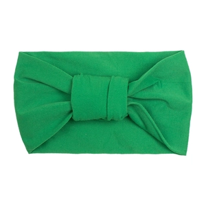 Close-up of green soft knit nylon headband with a decorative double knot for infants