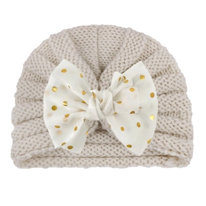 Knitted baby turban hat in beige with large gold polka dot bow detail for autumn