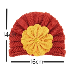 Detail showing red baby turban hat dimensions 16x14cm with yellow knit flower ornament