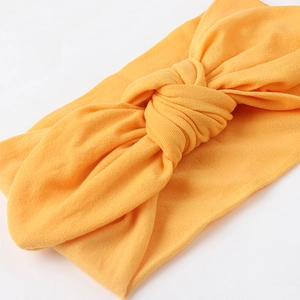 Close-up of bright yellow nylon baby headband with a soft textured knot design