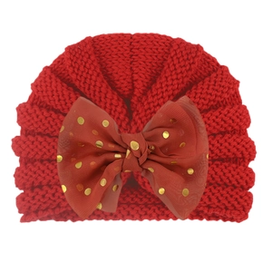 Detail view of baby knit beanie with large gold-dot mesh bow in dark red color