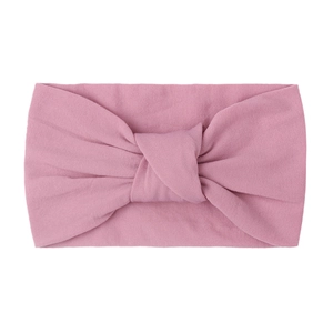 Detail of soft dusty pink knotted baby headband made of elastic double-layer nylon fabric