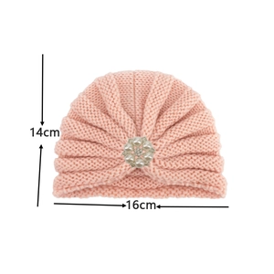 Vue détaillée de la taille d'un bonnet turban rose tricoté avec fleur en perles