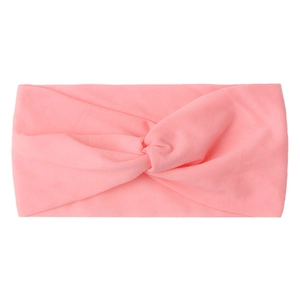Close-up of pink twisted nylon headband for babies featuring soft knitted fabric texture