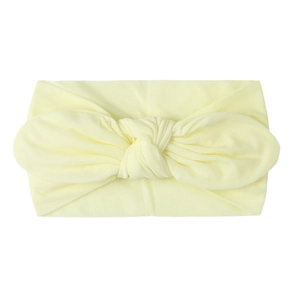 Macro detail of soft nylon baby turban headband with knot in pale yellow color