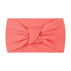 Detailed close-up of soft coral nylon headband with classic turban knot design