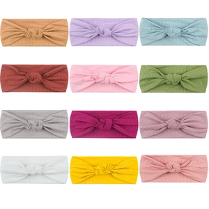 Detail showing 12 colors of ribbed elastic baby headbands with decorative knots