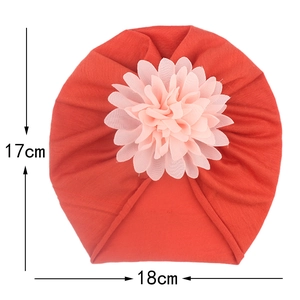 Détail du turban rouge pour bébé montrant la largeur de 18cm et la fleur rose brodée