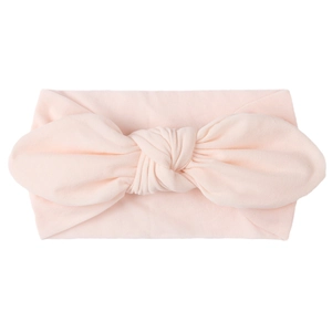 Soft peach pink nylon baby turban headband with a large knotted bow for newborns