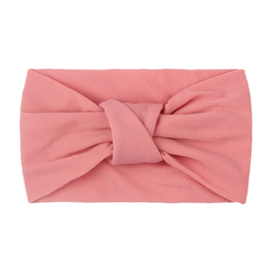 Detail of soft pink nylon knotted headband with flexible wide-brim fabric texture