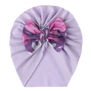 Detail of soft purple baby turban hat featuring a large floral print decorative bow