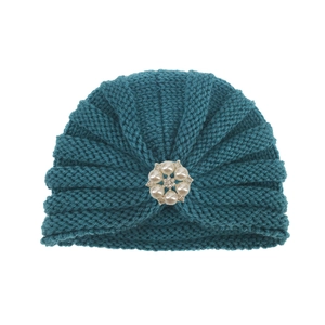 Détail du bonnet turban tricoté bleu sarcelle avec fleur en perles et strass