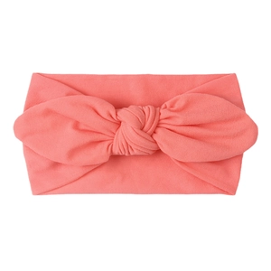 Detail of coral pink baby turban headband with soft knit fabric and large center knot