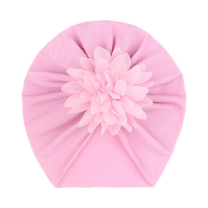Détail du bonnet turban rose pour bébé montrant le tissu doux et la fleur 3D décorative